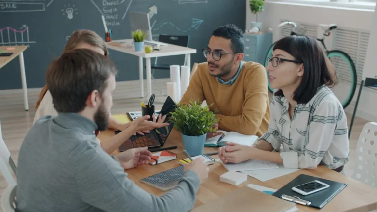 Equipo de trabajo reunido alrededor de una mesa en la oficina